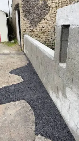 Maçon montant un mur en blocs béton
